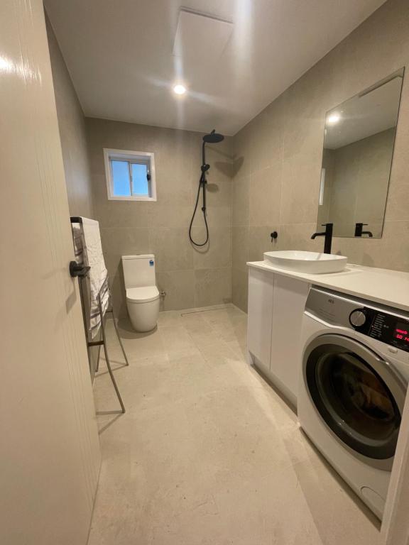 een badkamer met een wasmachine en een wastafel bij Salisbury Suburban Escape in Brisbane