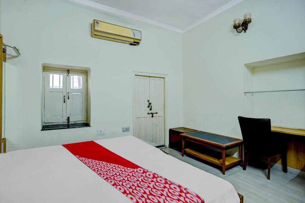 a bedroom with a bed and a desk and a piano at Hotel O Dayal Heritage in Hazārībāg