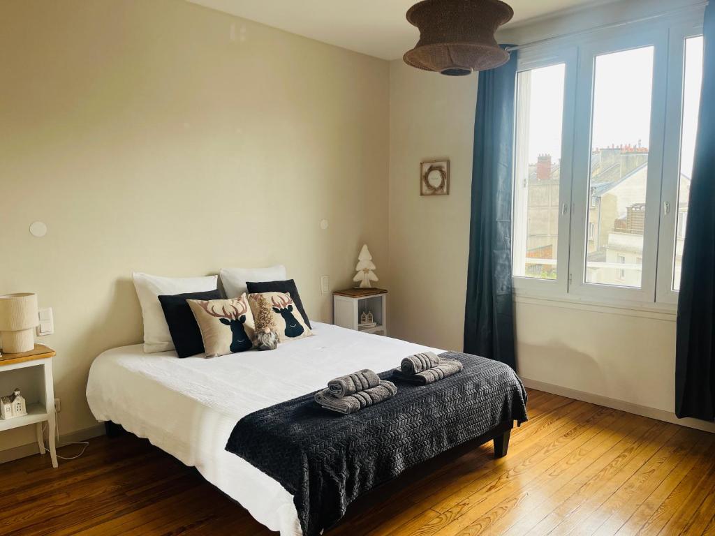 a bedroom with a bed and a large window at Le 5 - Spacieux 2 pièces Caen Centre Le Port in Caen