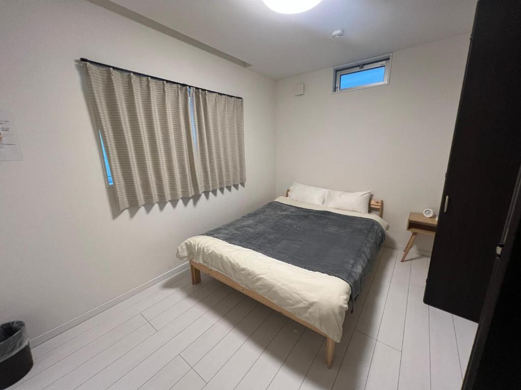 a small bedroom with a bed and a window at 花園之家 in Osaka