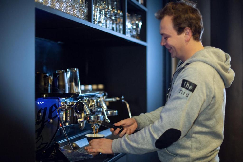 a man standing at a bar pouring a drink at Holiday Inn - the niu, Fender Amsterdam in Amsterdam