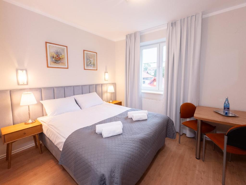 别尔斯克-比亚拉HARCERSKA 7 Pokoje Bielsko Biała的卧室里有一张床，床上放着两条毛巾。