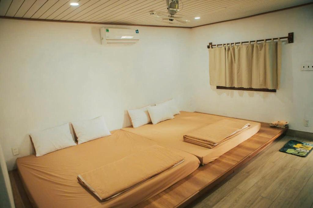 ein Schlafzimmer mit einem großen Bett in einem Zimmer in der Unterkunft Lalagigi Homestay in La Gi