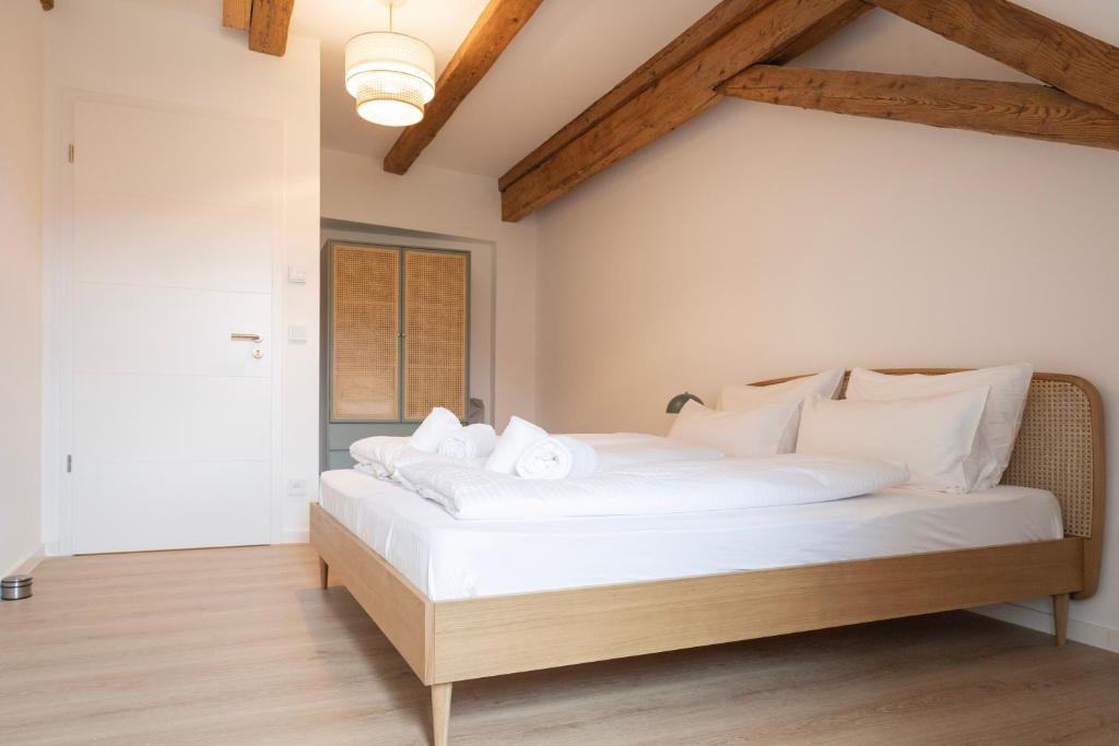 a bedroom with a bed with white sheets and pillows at ღLiboria Villa Münter in Murnau am Staffelsee