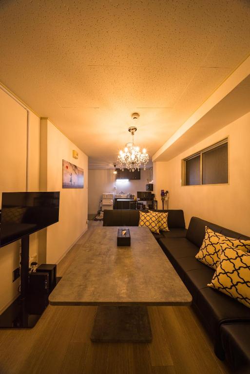 a living room with a couch and a chandelier at mikiHOTEL本川町303 - supported by COCOSTAY in Hiroshima