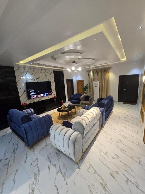 a large living room with couches and a tv at Eperorsuits in Ikot Omin