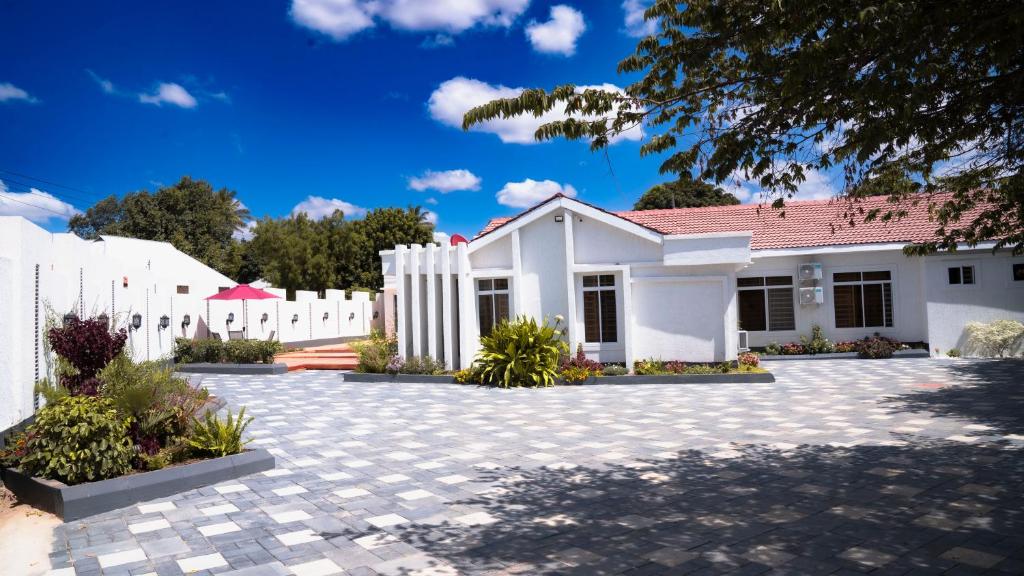 una casa blanca con techo rojo en Infinity Homes Apartment Dodoma, en Dodoma