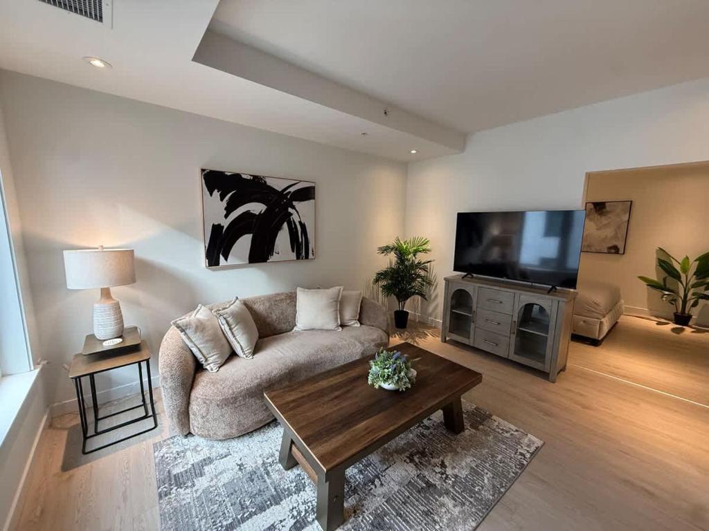 a living room with a couch and a flat screen tv at Bright warm & spacious 1 BR in North End Halifax in Halifax