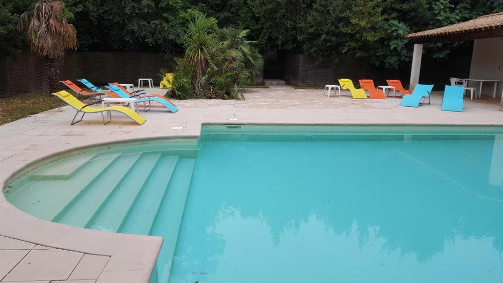 a swimming pool with chairs and a table and chairs at Chateau st-auriol - la bergerie in Saint-Pierre-des-Champs