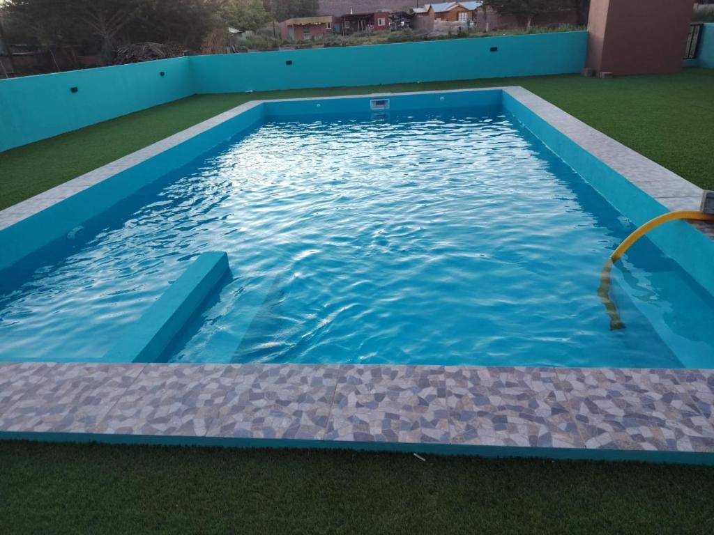 a swimming pool with a hose in the water at Hostal Ribera de Quitor in San Pedro de Atacama
