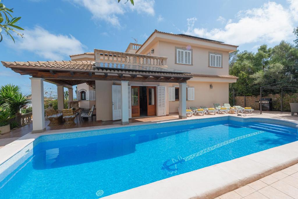 a villa with a swimming pool in front of a house at Your Island Villa Son Serra in Son Serra de Marina