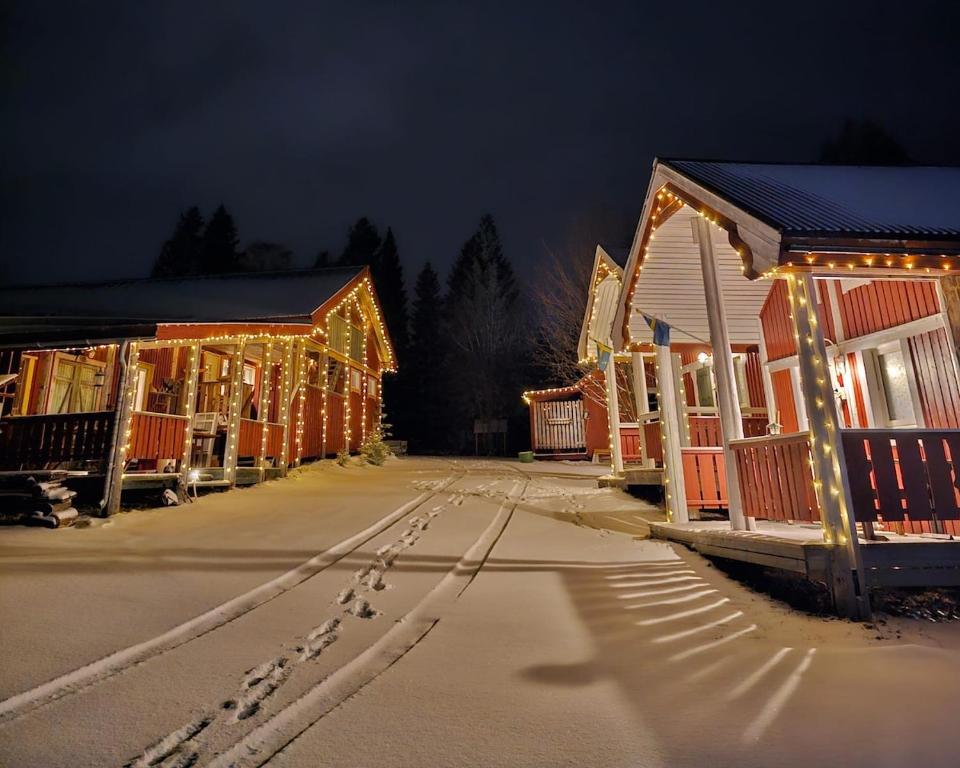 a row of houses decorated with christmas lights at night at Marlens mysiga B&B in Pålänge