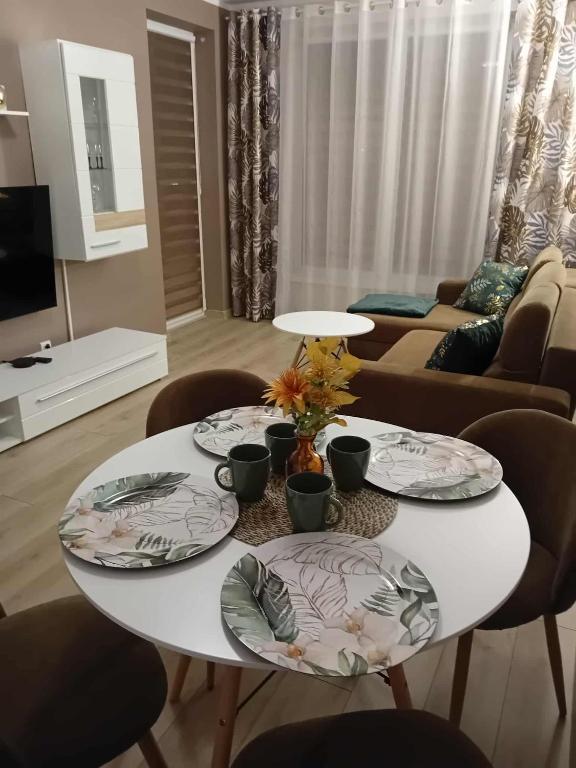 a white table with two plates on it in a living room at Apartament Zacisze in Kalisz