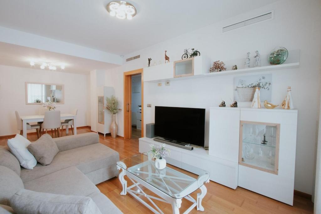ein Wohnzimmer mit Sofa und Fernseher in der Unterkunft Family & Friends Apartment with Pool in Torrent