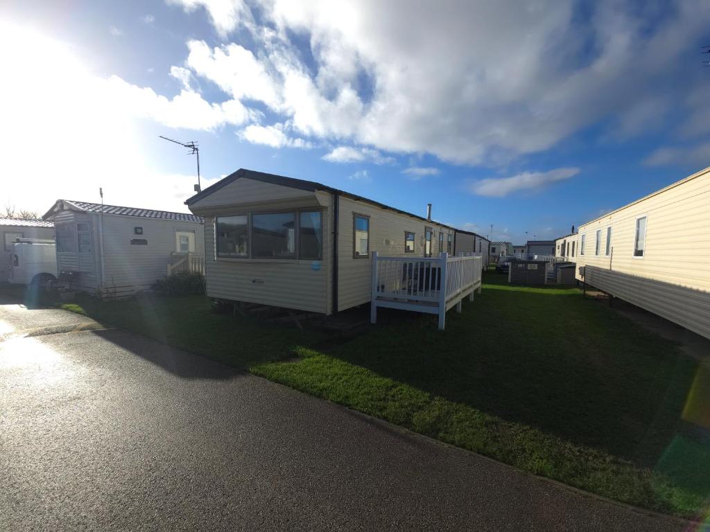 a tiny house in a yard next to a trailer at The Retreat Palm - Lido Beach Prestatyn in Prestatyn