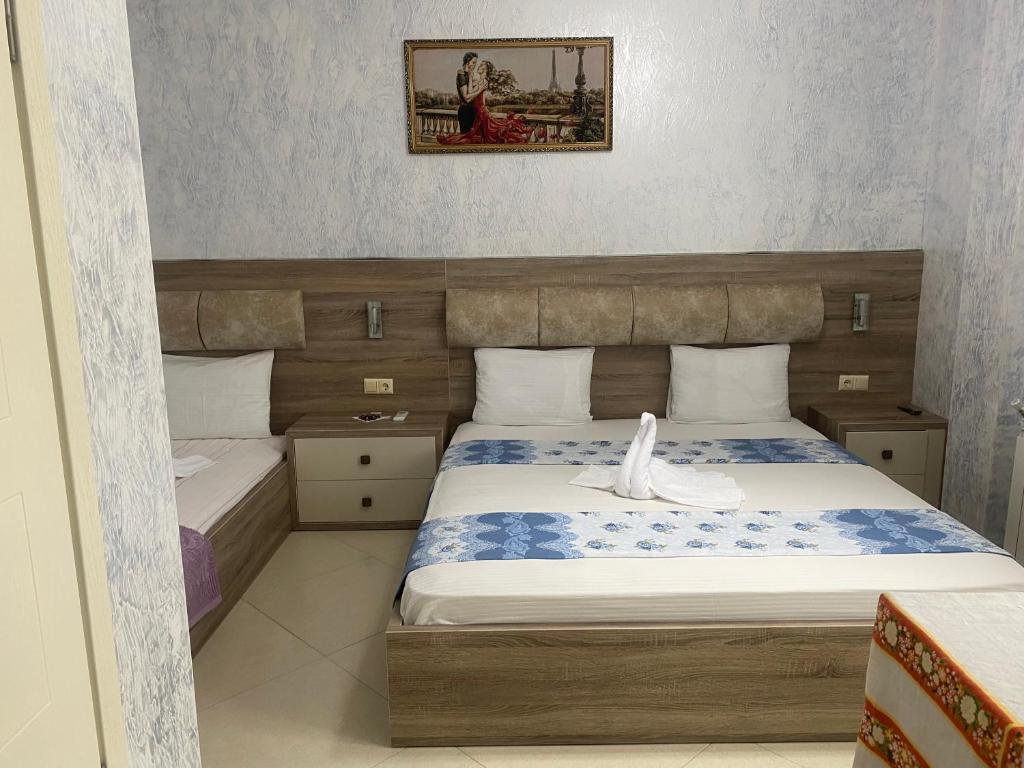 a small bedroom with a bed and a picture on the wall at Hotel Ergo in Batumi