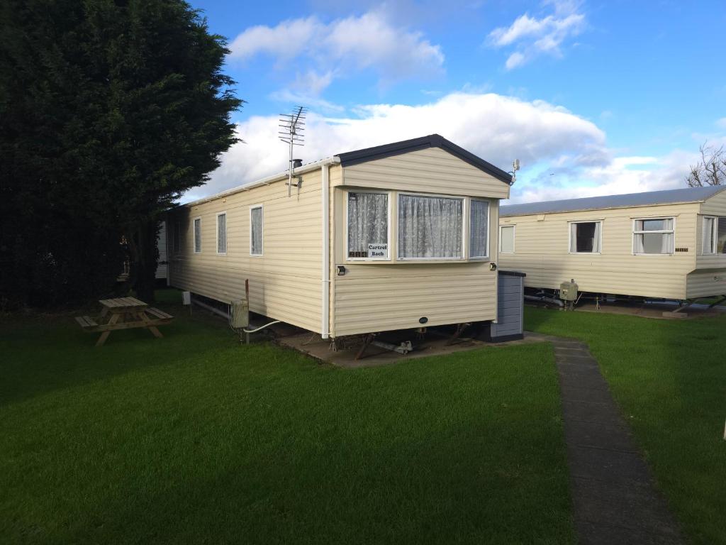 ein Mobilheim mit einem Picknicktisch im Garten in der Unterkunft The Retreat at Marine Holiday Park in Rhyl