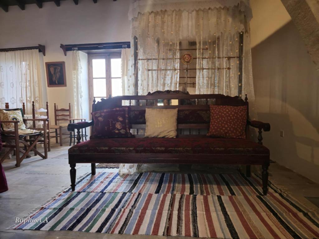 a living room with a couch and a rug at Lοfou-Queen in Lofou
