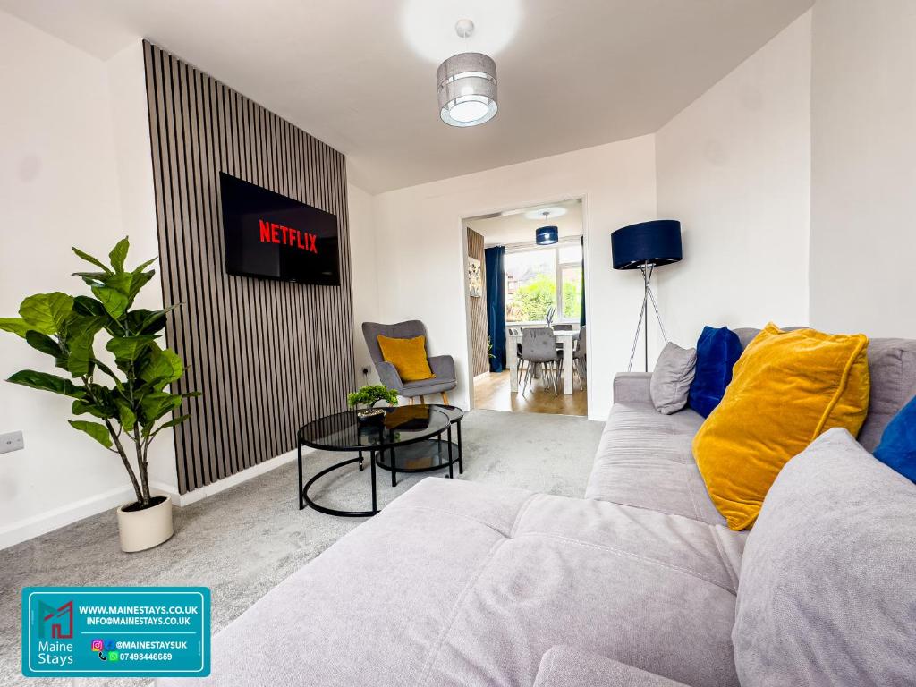 un salon avec un canapé et une table dans l'établissement Modern 3 Bedroom Home, 6 beds, Free Parking, 500MBS, Netflix, Near Coventry City Centre & Hospital, Contractors, Families, Apple Air Play, à Coventry