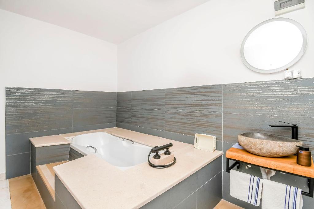 a bathroom with a bath tub and a sink at Apartments and Room Napoli in Bol