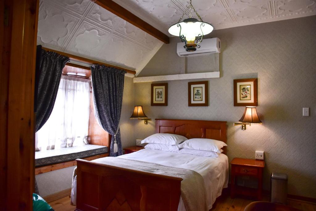 a bedroom with a large bed and a window at Hobbit Boutique Hotel in Bloemfontein