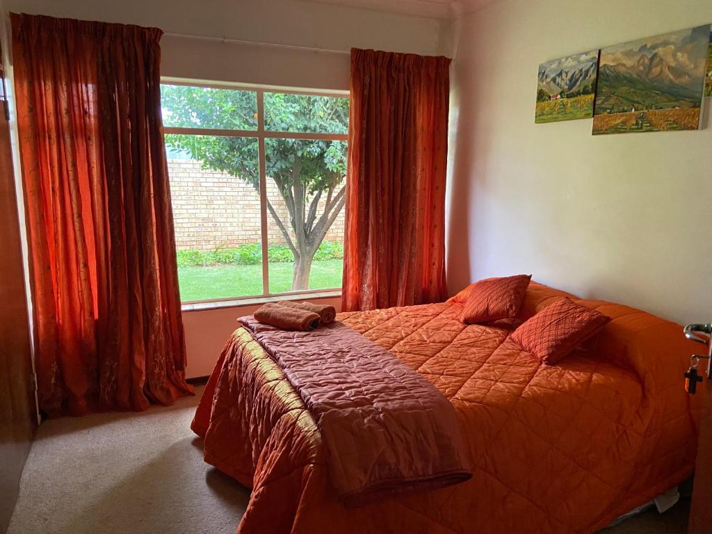 a bedroom with a bed and a large window at Highway Haven in Stilfontein