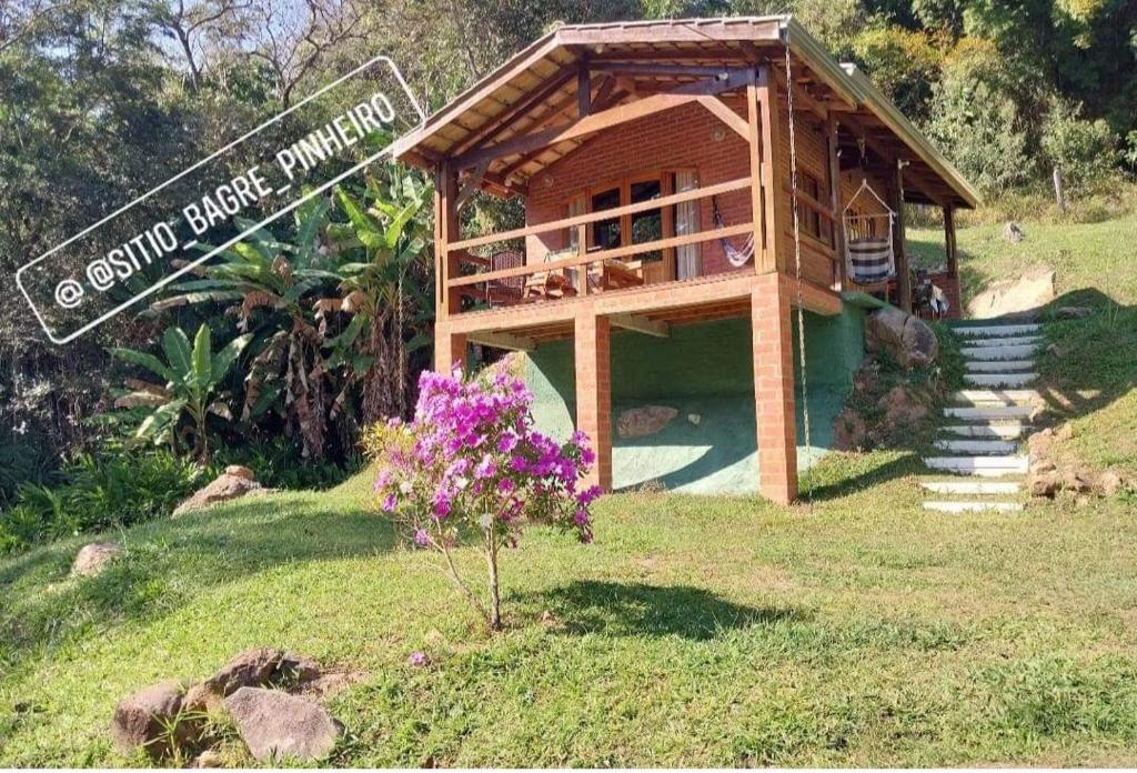 若阿诺波利斯Chale Bamboo Sitio Bagre Pinheiro的田野里一间小房子，旁边立着一块牌子