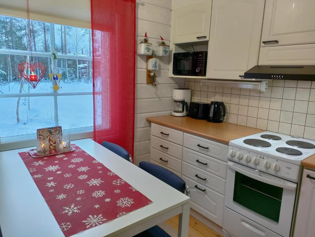 una cocina con una mesa y una estufa horno superior en Villa Bear's, en Rovaniemi