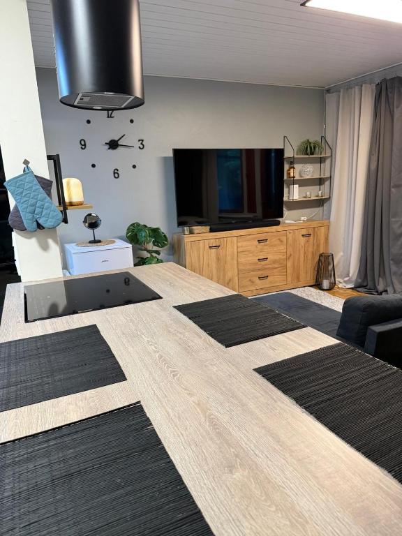 a living room with a large bed and a flat screen tv at Compact beautiful apartment with sauna in Kuusamo