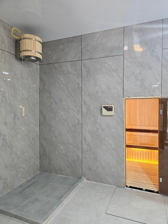 a room with a large gray wall with a wooden door at Zamin Hotel in Zomin