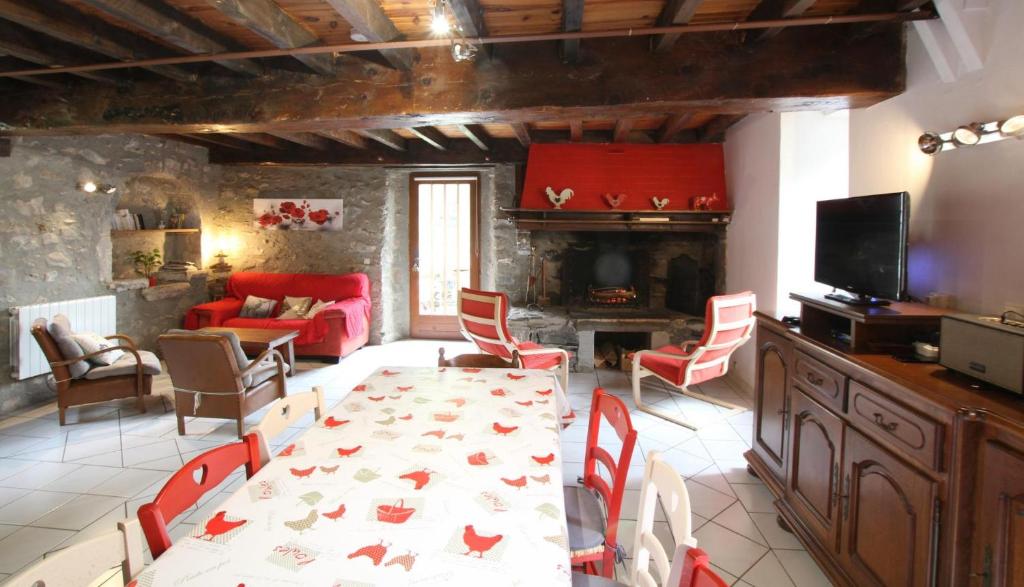 a living room with a table and chairs and a tv at Le lheze in Cette-Eygun