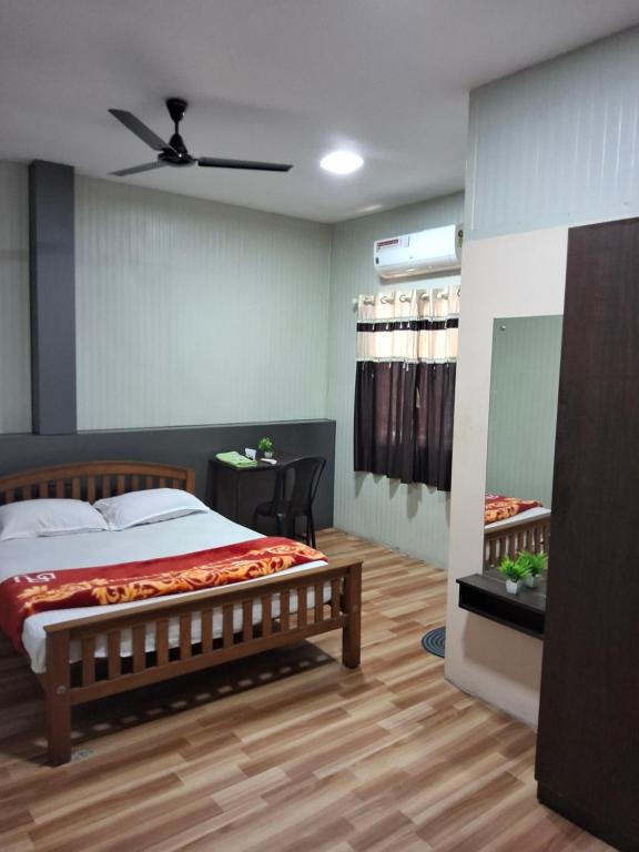 a bedroom with a large bed and a table at Vidara Budget Stay in Trivandrum
