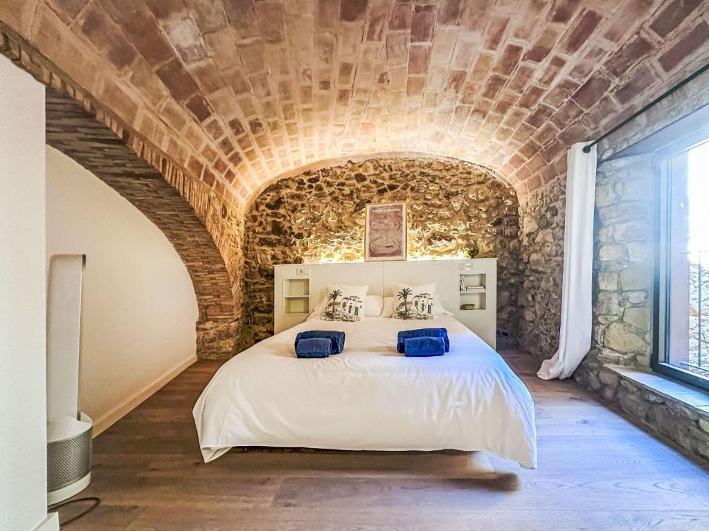 une chambre avec un grand lit dans un mur de briques dans l'établissement Holiday Home Can Caritat by Interhome, à Pals