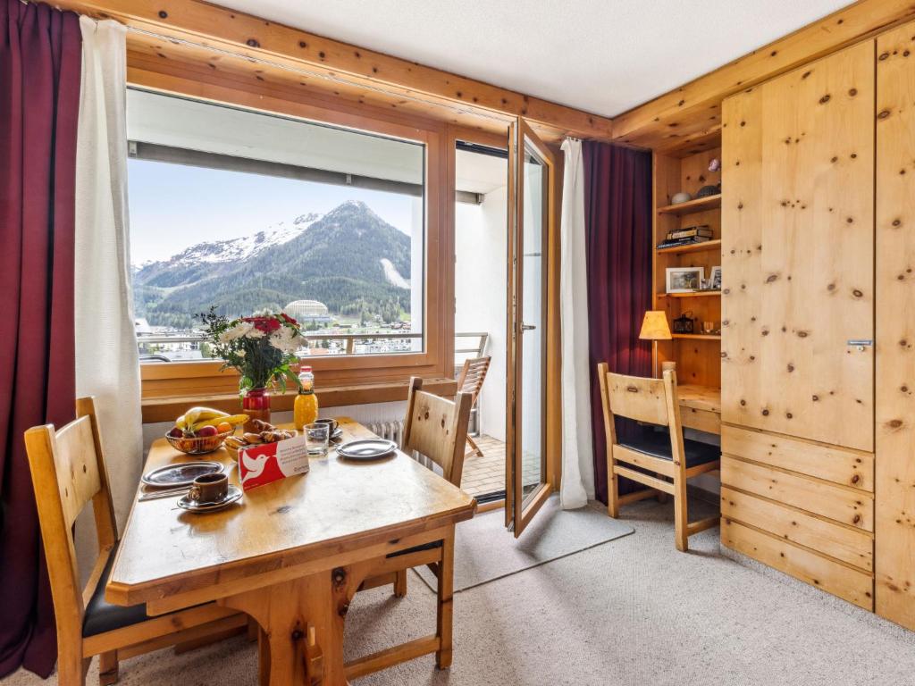 ein Esszimmer mit einem Tisch und Bergblick in der Unterkunft Apartment Guardaval - Utoring-3 by Interhome in Davos