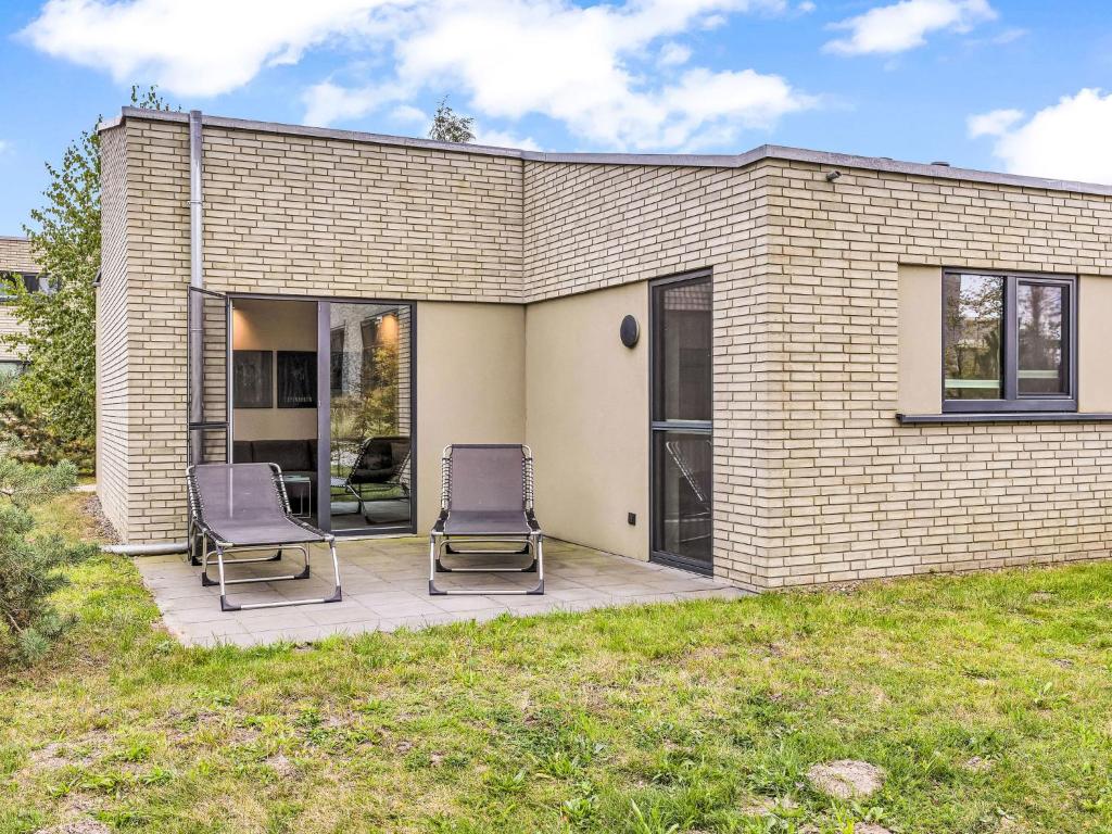 two chairs on a patio in front of a house at Holiday Home Windlicht by Interhome in Lembruch