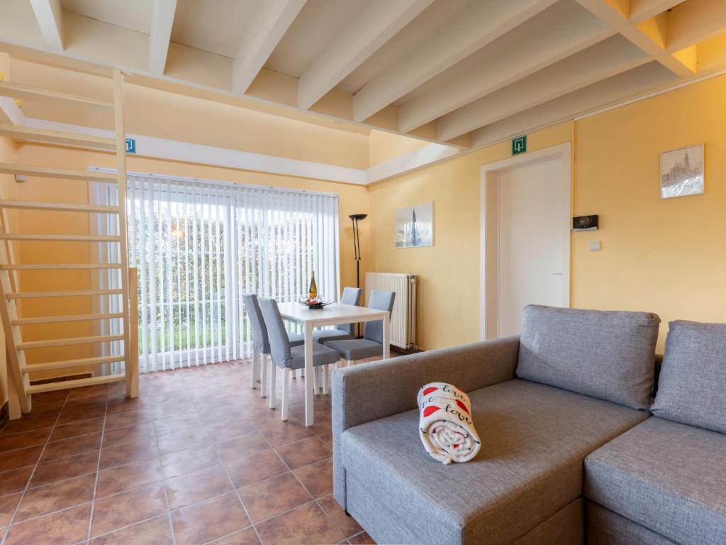een woonkamer met een bank en een tafel bij Holiday Home Polderzicht with parking by Interhome in Mispelburg