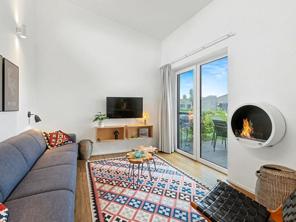 a living room with a couch and a fireplace at Holiday Home Komfortzone by Interhome in Lembruch