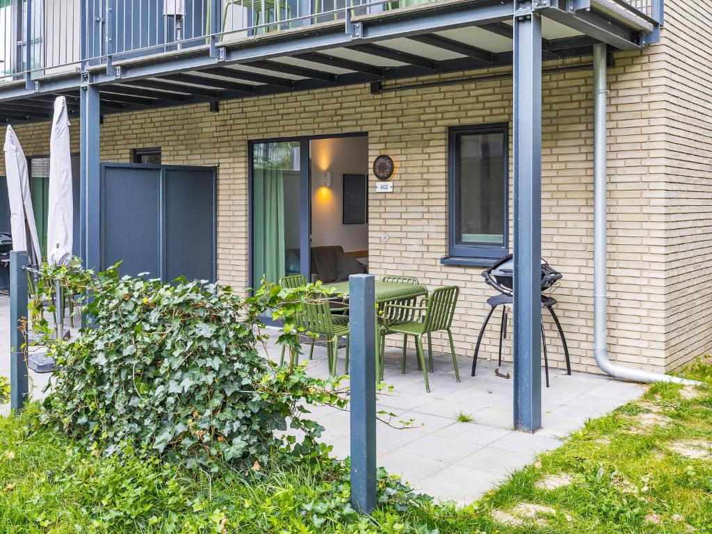 a patio with a table and chairs next to a building at Apartment Seeleuchten by Interhome in Lembruch