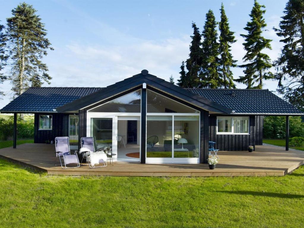 a small house with a deck and two chairs at Holiday Home Antonina - 775m from the sea by Interhome in Gudmindrup