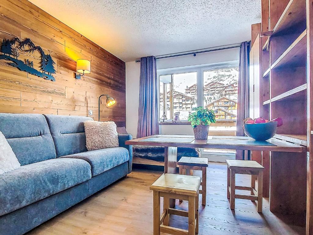 a living room with a blue couch and a table at Studio Les Olympiades-16 by Interhome in Val Thorens