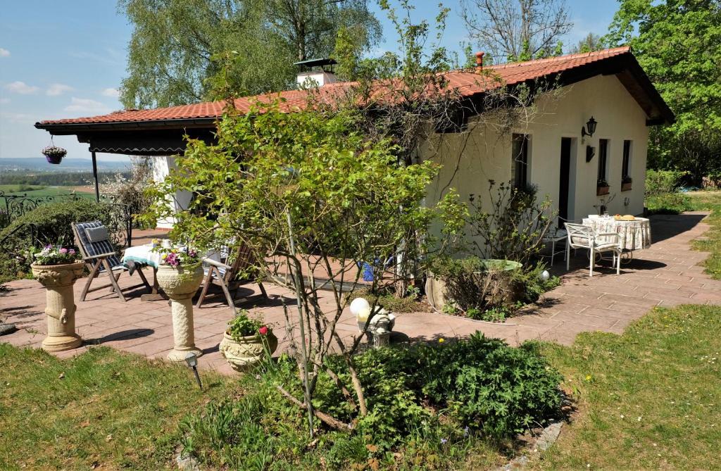 a small house with a table and chairs in front of it at Ferienhaus Mit Einer Umwerfenden Panoramaaussicht in Glotzdorf
