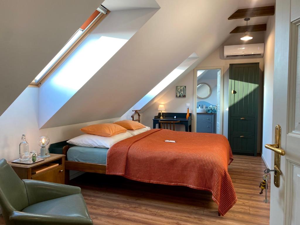 um quarto com uma cama com um cobertor laranja em Hatablak Köveskál em Köveskál