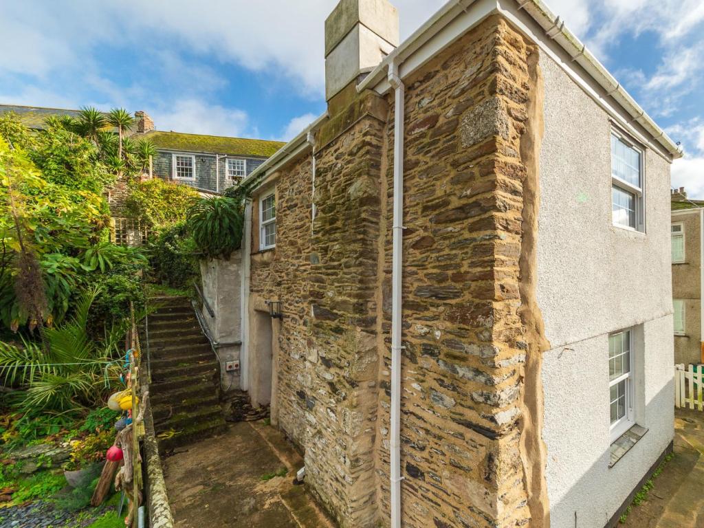 an old stone building with a staircase next to it at Holiday Home Shanty Cottage by Interhome in Mevagissey