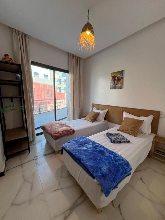 Hostel Atlantic view Tamraght في Tamraght Ouzdar: سريرين في غرفة ذات نافذة كبيرة