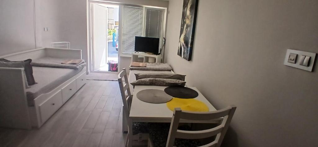 a dining room with a table and chairs and a tv at Студио за двама в центъра на град Бургас in Burgas City