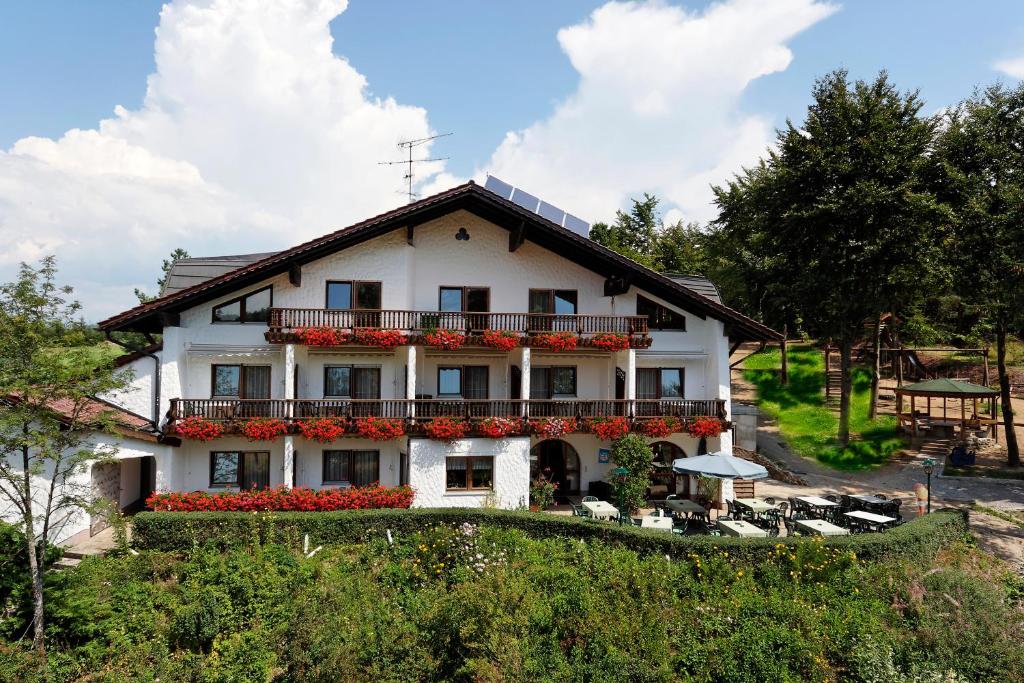 a large white house with a balcony at Pension Bergstub`n in Saldenburg
