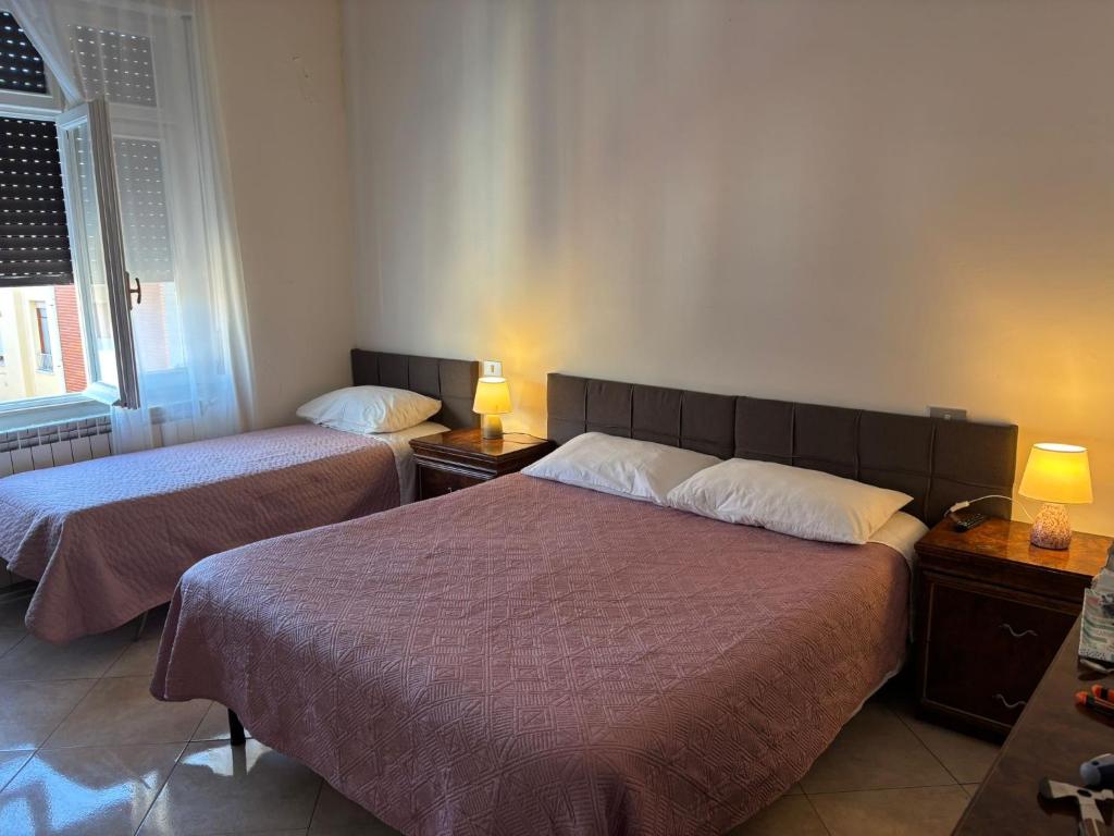 a hotel room with two beds and two lamps at B&B Altea in Pescara