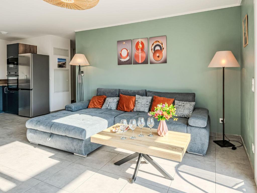 ein Wohnzimmer mit einem blauen Sofa und einem Tisch in der Unterkunft Apartment le clos de la mayade by Interhome in Mimizan
