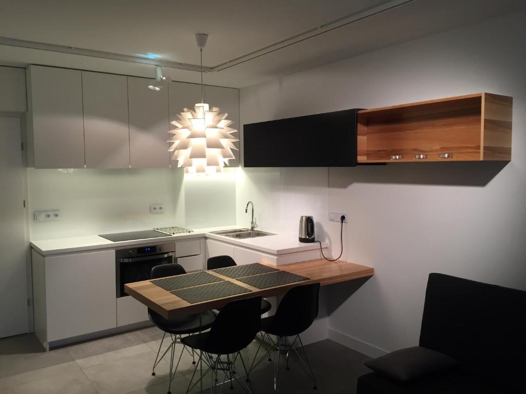 a kitchen with a table and some chairs in it at MOHO apartament in Dziwnówek