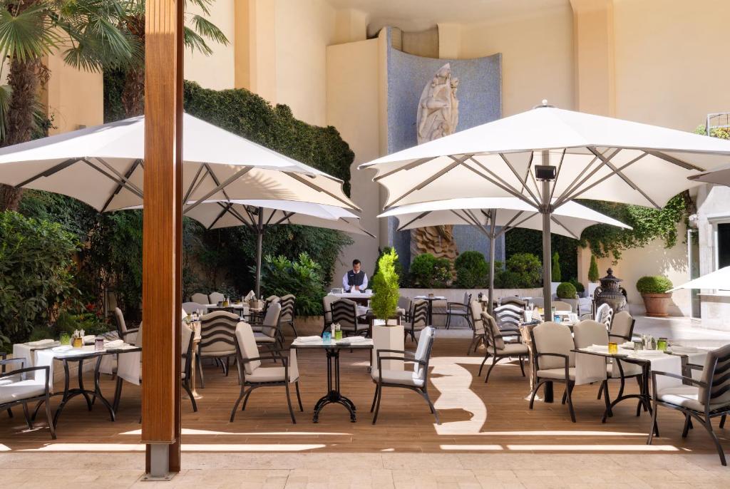 a restaurant with tables and chairs and umbrellas at InterContinental Madrid by IHG in Madrid